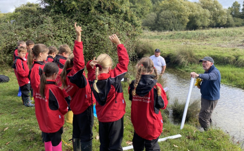 children measuring width and flow of a river