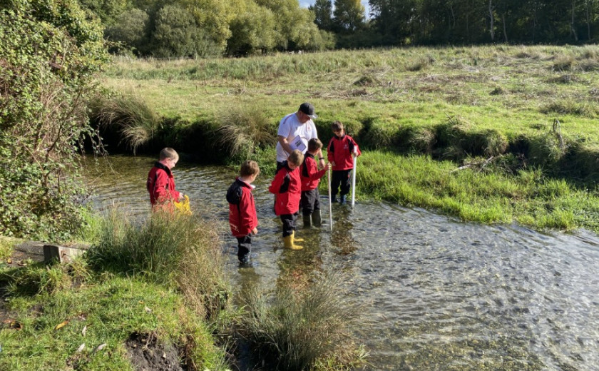 children measuring width and flow of a river